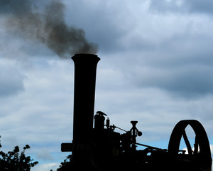 Steam powered vintage traction engine making smoke from firing with coal.