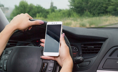 The girl goes behind the wheel of the car and holds the phone. Inattention while driving, she can get into an accident  E