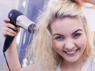 Fototapeta premium Woman drying hair in bathroom