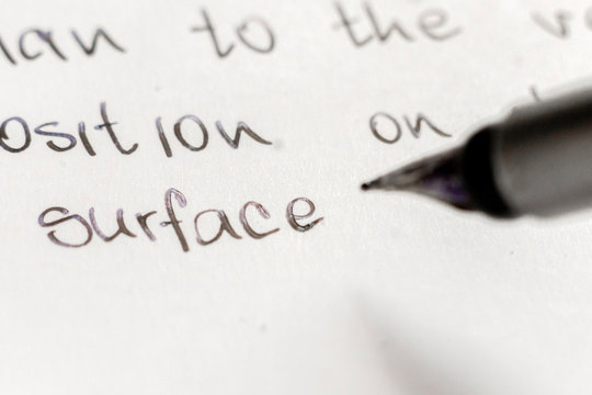 macro shot of fountain pen writing on white surface