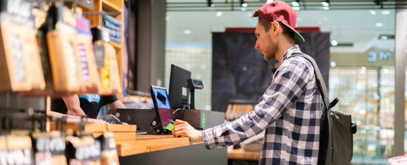 young man making a purchase and paying at the cash deck in the store
