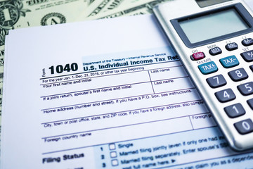 Tax Return form 1040 and dollar banknote : U.S. Individual Income.