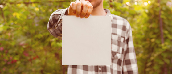 farmer hands holding a square white empty frame with copy space