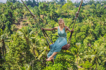 Young woman swinging in the jungle rainforest of Bali island, Indonesia. Swing in the tropics....