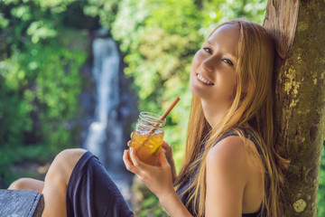 Closeup portrait image of a beautiful woman drinking ice tea with feeling happy in green nature and...