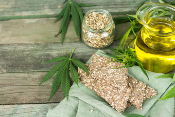 cannabis cookies jug of oil seeds wooden background green leaves top view