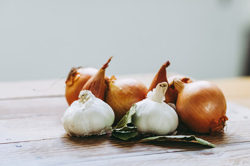 Ail oignons et laurier posés sur une table en bois