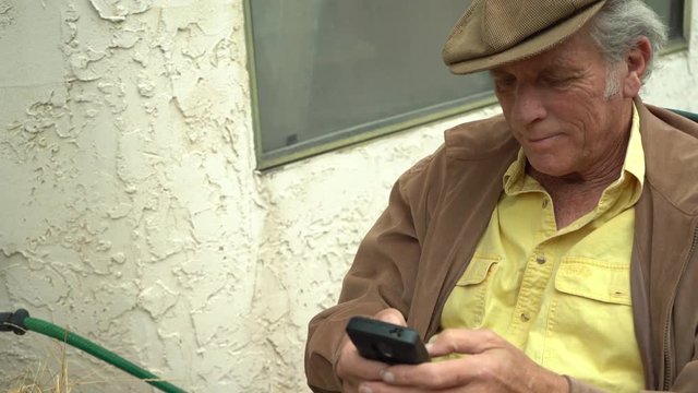 Older Man Texting On His Smart Phone, Zooming In