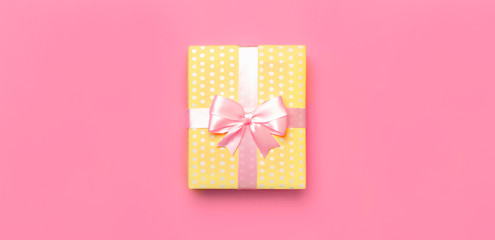 Gift or present box with beautiful festive ribbon on pink background top view. Flat lay composition for celebration, holiday, birthday, Valentine's Day, March 8, mother day, wedding. Congratulation