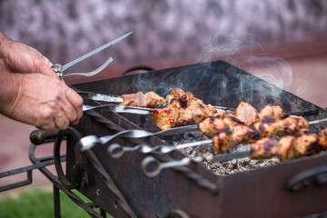 Cooking shashlik on the mangal in nature. Selective focus.