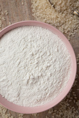 Gluten free rice flour in a pink bowl, top view. Flat lay, overhead, from above. Close-up.