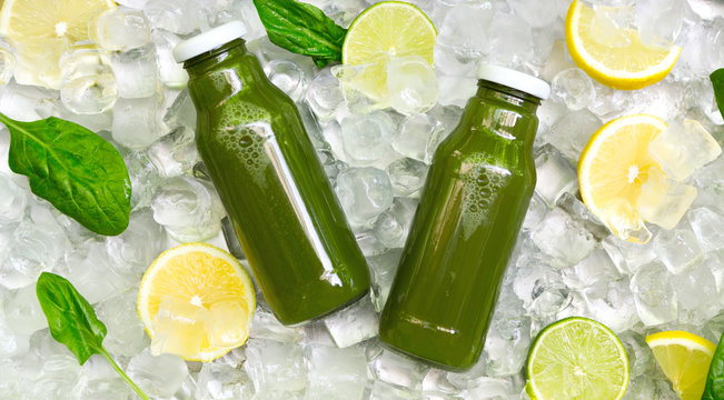 Green Detox drink in glass bottle with fresh lemons and mint