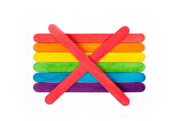 An red X symbol over a rainbow flag made of popsicle / ice cream sticks. Being against, opposing...