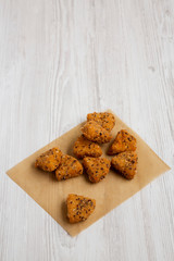 Fried camembert on a baking sheet on a white wooden background, low angle view. Copy space.