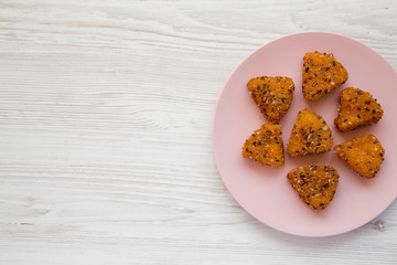 Fried camembert on a pink plate on a white wooden background, top view. Flat lay, overhead, from above. Space for text.