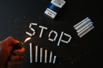 Stop smoking sign from cigarettes. Dangerous habit. Harmful for health. Man holds lighter in hands.