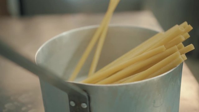 Chef cook spaghetti with thick macaroni in closeup