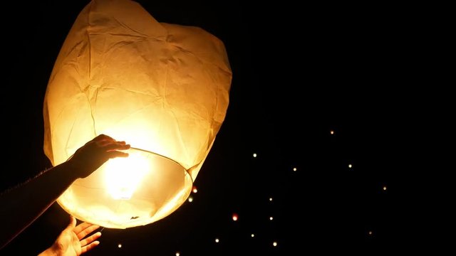 Floating Lanterns Are Lit And Hands Are Letting Go Of Them. Chinese Lanterns
