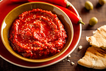 Healthy spicy, creamy vegetarian appetizer or snack with roasted red pepper dip with harissa, pita...