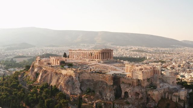 Aerial view of a slide from the drone on the panorama of residential buildings of the city of Athens, on the main symbol of ancient Greece, Acropolis at sunrise. The lights sun. World Heritage sites