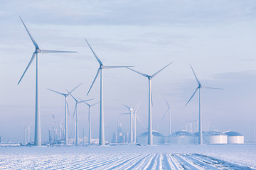 Windmills in a white winter landscape with snow producing green and sustainable energy to reduce global warming - Eemshaven, Groningen, The Netherlands - 278510003
