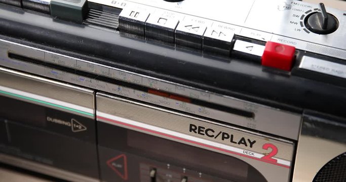 Push play on a Retro stereo recrod player ghetto-blaster on the table / detail
