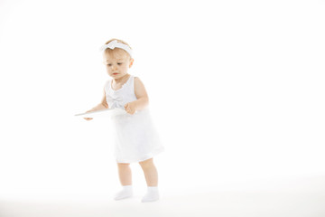 little girl all in white with a tablet