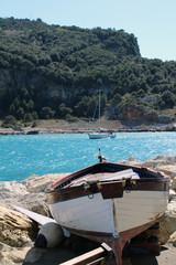 Barcha in secca con mare e promontorio