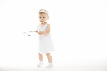 little girl all in white with a tablet