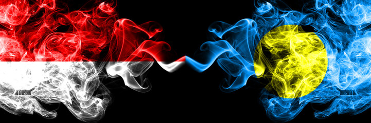 Indonesia vs Palau, Palaulan smoky mystic flags placed side by side. Thick colored silky smoke flags of Indonesia and Palau, Palaulan