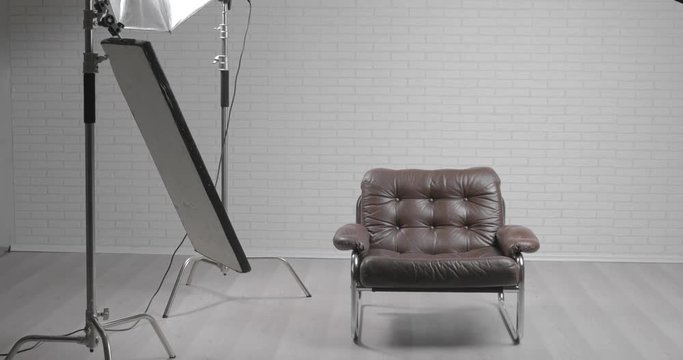 Photo studio with leather chair, c-stand, bouncing desk and octabox / steady cam moving shot