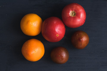 Red, yellow and brown tommato on dark blue wooden background