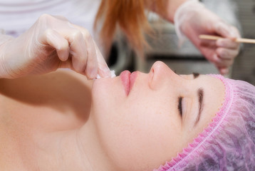 Obraz na płótnie Canvas Young woman receiving facial epilation close up. Cosmetologist removes hair on face. Beauty salon, mustache depilation