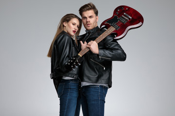 Rock couple posing while she is pulling his jacket