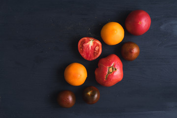 Red, yellow and brown tommato on dark blue wooden background