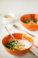 Healthy savory oatmeal with greens and Bulgarian yogurt high in fiber and protein in bowl on gray background with copy space,easy to prepare for breakfast or brunch.Healthy food,balanced diet concept