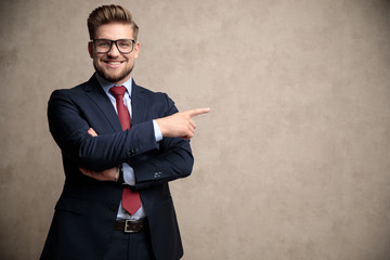 Positive businessman pointing to the side and smiling