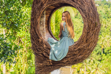 Bali trend, straw nests everywhere. Young tourist enjoying her travel around Bali island,...