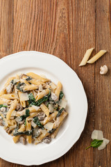 Penne pasta with spinach and mushrooms. Sprinkled with cheese.