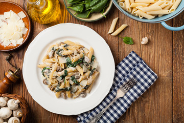 Penne pasta with spinach and mushrooms. Sprinkled with cheese.