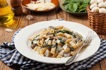 Penne pasta with spinach and mushrooms. Sprinkled with cheese.