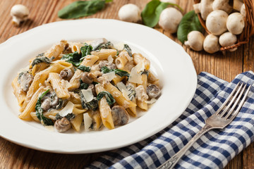 Penne pasta with spinach and mushrooms. Sprinkled with cheese.