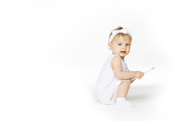 little girl all in white with a tablet