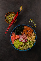 Hawaiian salmon poke bowl with seaweed, avocado, sesame seeds.