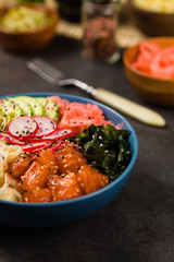 Hawaiian salmon poke bowl with seaweed, avocado, sesame seeds.