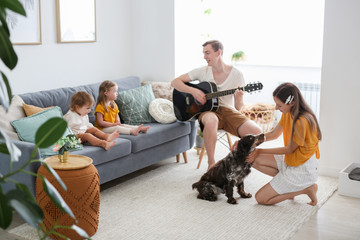 happy young caucasian family with dog at home