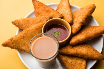 crispy Potato triangles or batata vada covered with bread crumbs and then deep fried. served with tomato ketchup. selective focus