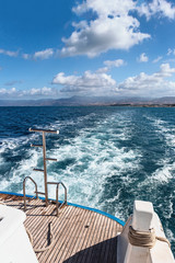 view from the stern of the yacht to the blue Mediterranean Sea and the island of Cyprus in the summer on a sunny day