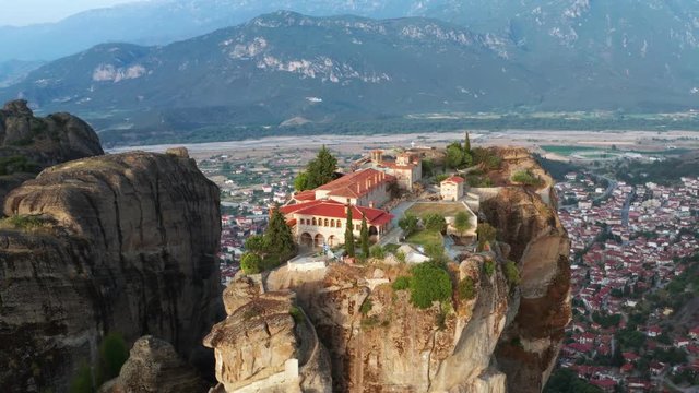 Aerial view of a slide from a drone on a panorama of a mountain range. Kalambaka city, Greece. The tops rocks of Meteora. Orthodox monastery in the mountains of Meteora. Monastery of the Holy Trinity