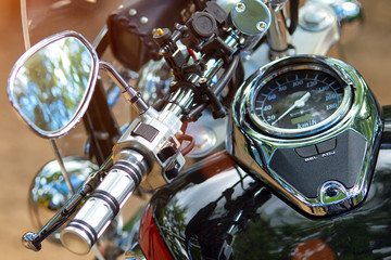 Fototapeta premium The chromed handlebar of a motorcycle.Travel and freedom, outdoor activities. View of motorcycle handlebar in the background many motorbikes blurred, concept of speed and travel in nature